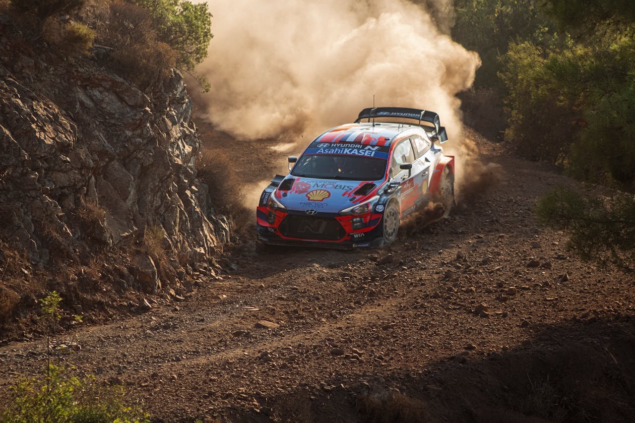 Exciting rally race car speeding on a dusty dirt road, showcasing dynamic motion and adventure.